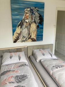 twee bedden in een kamer met een schilderij aan de muur bij 't Vosje in Ermelo