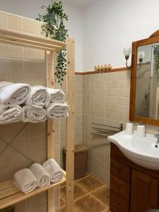 a bathroom with a sink and towels on a shelf at Casa Carmen by VG in Maro