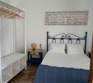 a bedroom with a blue and white bed and a table at Casa Carmen by VG in Maro