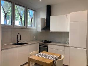 a kitchen with white cabinets and a wooden table at Neptune in Francavilla al Mare