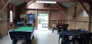 uma sala com uma mesa de bilhar e jogos de arcada em Camping le Balcon de la Baie em Saint-Marcan
