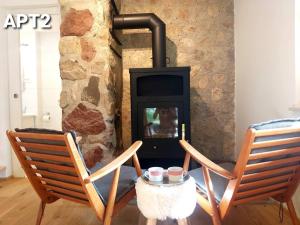 - deux chaises et un poêle à bois dans la chambre dans l'établissement Alpine Village Home, à Bohinj