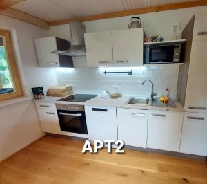 - une cuisine avec des placards blancs et un évier dans l'établissement Alpine Village Home, à Bohinj