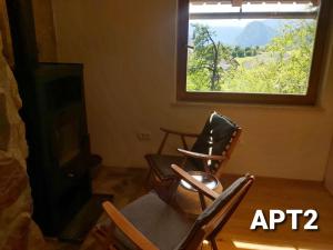 a living room with two chairs and a fireplace at Alpine Village Home in Bohinj +37 photos