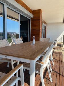 una mesa de comedor de madera y sillas en una terraza en Bitcoin and Ethereum Deluxe Apartments en Bar