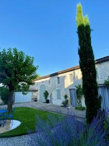 un jardín frente a una casa con un árbol en Gîte des oiseaux, en Préchac