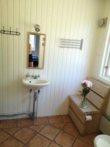baño con lavabo y jarrón de flores en Kulhuse Hus, en Jægerspris