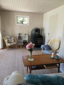 sala de estar con mesa y estufa de leña en Kulhuse Hus, en Jægerspris