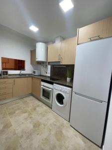a kitchen with a white refrigerator and a dishwasher at UIM Mediterraneo PB Felipe 1 Wifi in Puerto de Sagunto