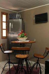 una cucina con tavolo, sedie e frigorifero di Aconchego do lar a Gramado