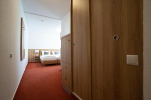 Habitación con dormitorio con cama y armario. en Nineofive Hotel en Jena