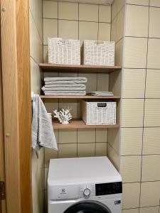 a laundry room with a washing machine and towels at Küüni Guest Apartment in Tartu