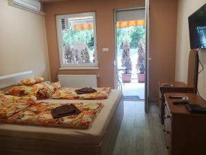 a bedroom with two beds and a window at Relax Beach Apartman in Hajdúszoboszló