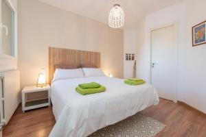 a bedroom with a large white bed with green towels on it at Apartamento Fontargent 2 in Soldeu