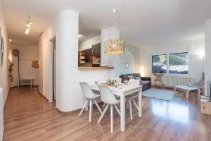 cocina y sala de estar con mesa blanca y sillas en Apartamento Fontargent 2, en Soldeu