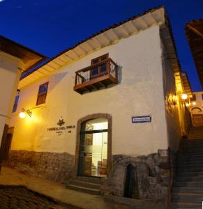 ein weißes Gebäude mit einer Tür und einem Balkon in der Unterkunft Hotel Sueños del Inka in Cusco