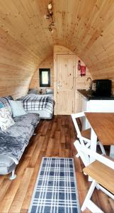 una camera con divano e tavolo in una cabina di The Pod at Hollingwell House - Glamping NC500 Edderton a Balblair