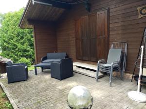 a patio with two chairs and a couch and a table at Landhaus/Holzhaus in Bad Wünnenberg