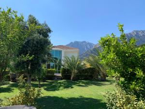 a house with a garden with mountains in the background at Luxury Villa for rent in Kemer, Göynük Antalya in Antalya