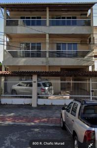 維多利亞的住宿－Bento Ferreira Hostel，两辆汽车停在大楼前