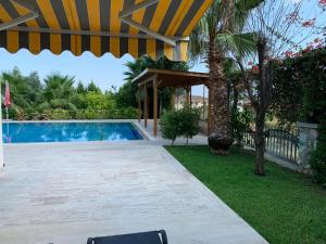 a swimming pool in a yard with a umbrella at Luxury Villa for rent in Kemer, Göynük Antalya in Antalya