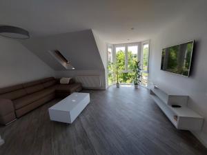 a living room with a couch and a tv at Bagoly Apartman in Eger