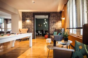 - un salon avec une table de billard et des chaises dans l'établissement Logis Villa C Hôtel, à Bourges