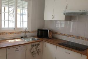 a kitchen with a sink and a microwave at Casa, sol y playa 365 días!! in San Juan de los Terreros