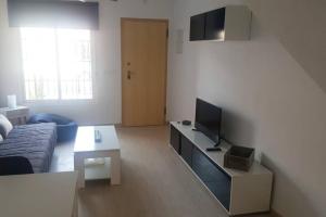 a living room with a couch and a television at Casa, sol y playa 365 días!! in San Juan de los Terreros