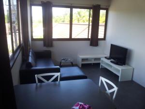 a living room with two couches and a tv at Living Room Apartments Bang Lut Beach KhaoLak in Bang Sak