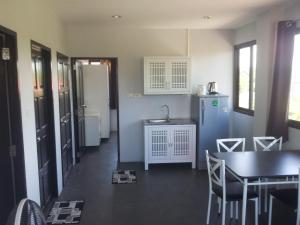 a kitchen and dining room with a table and a refrigerator at Living Room Apartments Bang Lut Beach KhaoLak in Bang Sak