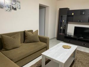 a living room with a couch and a coffee table at SELLADA APARTAMENT - Free Private Parking,AC,Wi-Fi in Carei