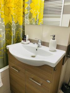 a bathroom with a white sink and a shower curtain at SELLADA APARTAMENT - Free Private Parking,AC,Wi-Fi in Carei +22 photos