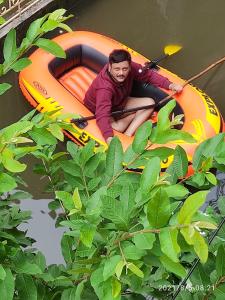 een man zit in een kajak op het water bij Green Home Stay Kolkata in Calcutta