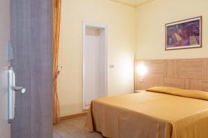 A bed or beds in a room at Hotel Corinna
