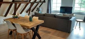 a living room with a table and a couch at Appartement Badnieuweschans in Bad-Nieuweschans