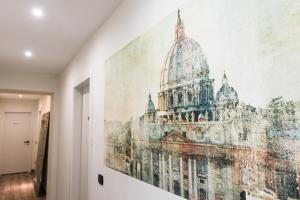 a large painting of a building on the wall in a hallway at St. Peter Manor in Rome