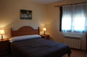 - une chambre avec un lit, deux lampes et une fenêtre dans l'établissement APARTAMENTOS LAS ERAS, à El Negredo