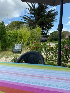 a table with an umbrella and a chair at Le sable chaud in Saint-Pierre-dʼOléron