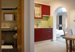 a kitchen with red cabinets and a dining room at Villa Gottfried Appartment in Eggen