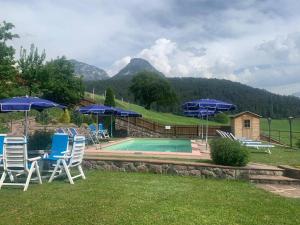 um grupo de cadeiras e guarda-sóis ao lado de uma piscina em App. Eichenheim em Fiè