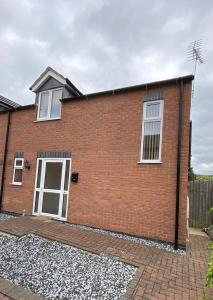 a red brick house with white windows and gravel at Hygge Homes - Modern 1 bed house in Lincoln