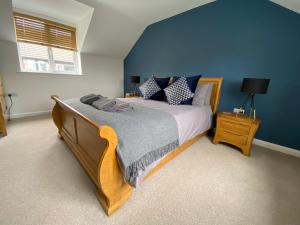 a bedroom with a large bed with blue walls at Hygge Homes - Modern 1 bed house in Lincoln