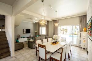 una sala da pranzo e un soggiorno con tavolo e sedie di Casa com área gourmet e piscina na praia do Indaiá a Caraguatatuba