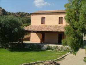 une grande maison avec une cour et un arbre dans l'établissement Torre Russo, à Guardavalle