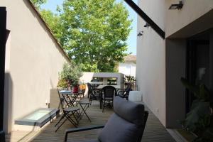 un patio con sillas y mesas en una terraza en La villa du chai, en Lézignan-Corbières