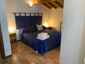 a bedroom with a blue bed with two night stands at Villa Canapa in Campogalliano