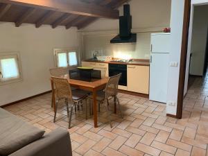 a kitchen with a table and chairs and a refrigerator at Villa Canapa in Campogalliano