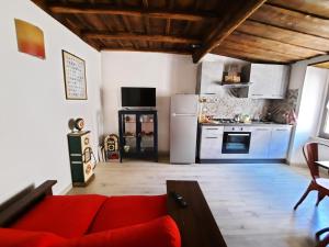 uma sala de estar com um sofá vermelho e uma cozinha em Viterbo alloggio turistico hipster house em Viterbo