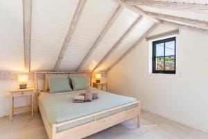 een slaapkamer met een bed en een raam bij Villa Horizonte Azul by Holiday Rental Madeira in Ponta do Sol +42 foto's